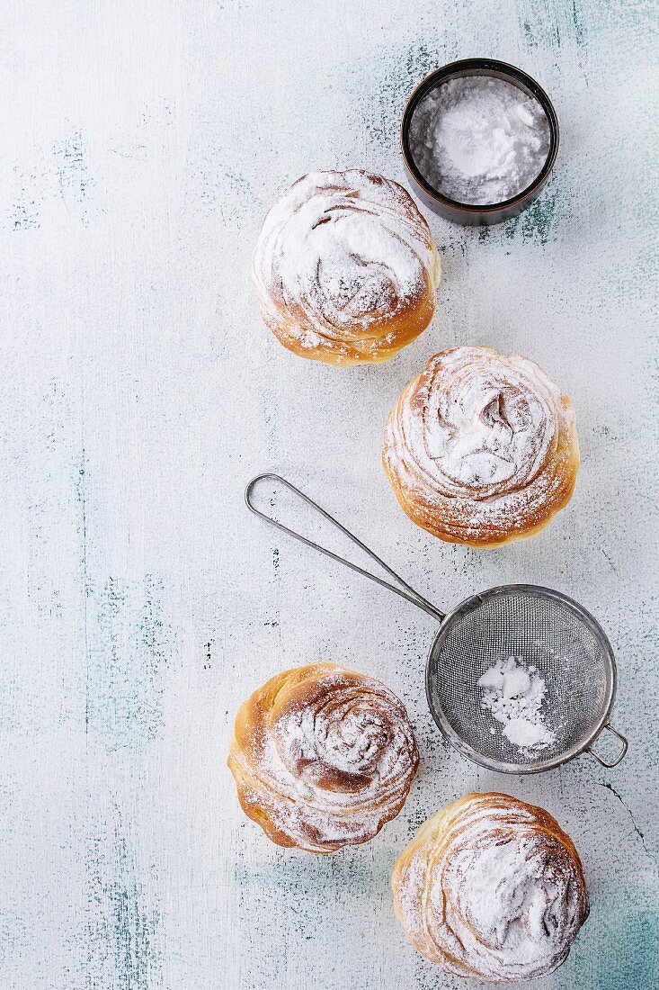 Modern pastries cruffins, with sugar powder served with vintage sieve