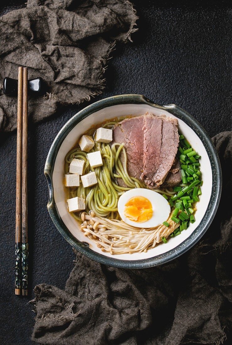 Asiatische Suppe mit Grüntee-Sobamudeln, Rindfleisch, Ei, Pilzen, Frühlingszwiebeln und Tofukäse