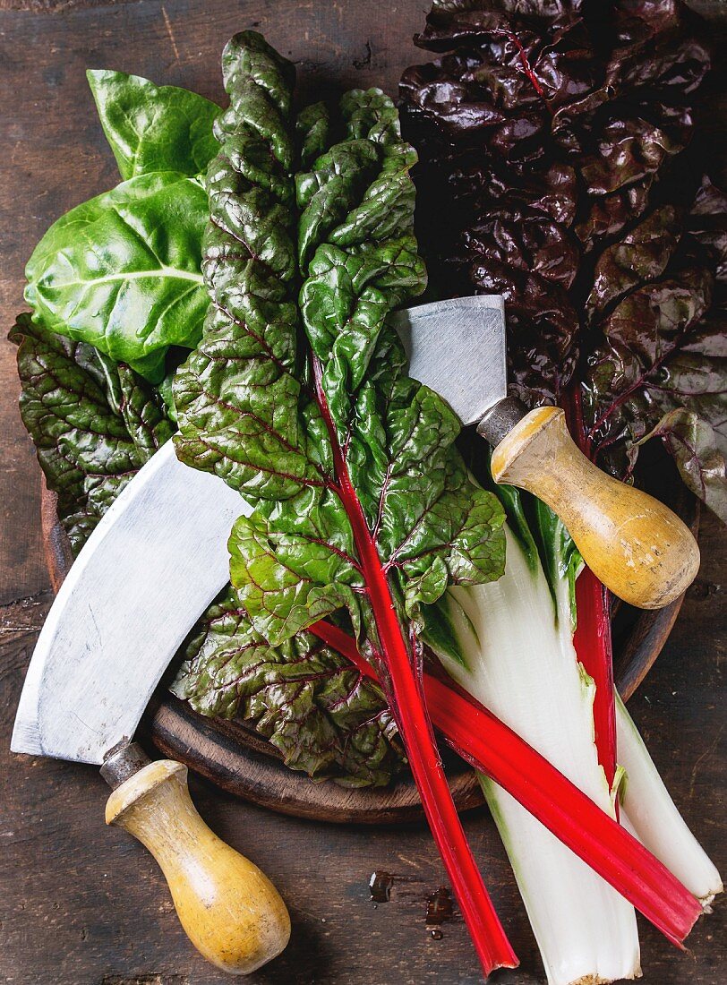 Variety of fresh chard mangold salad leaves on wooden chopping board