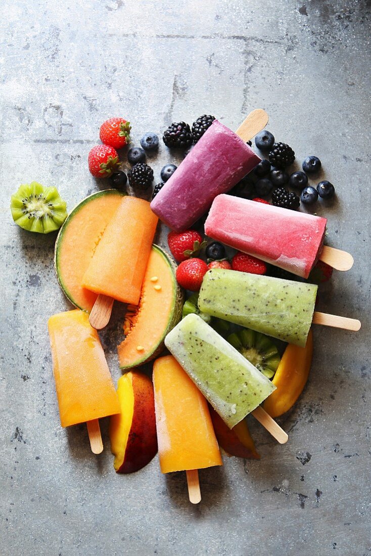 Eis am Stiel mit Kiwi, Mango, Melone, Heidelbeeren, Brombeeren und Erdbeeren auf frischem Obst