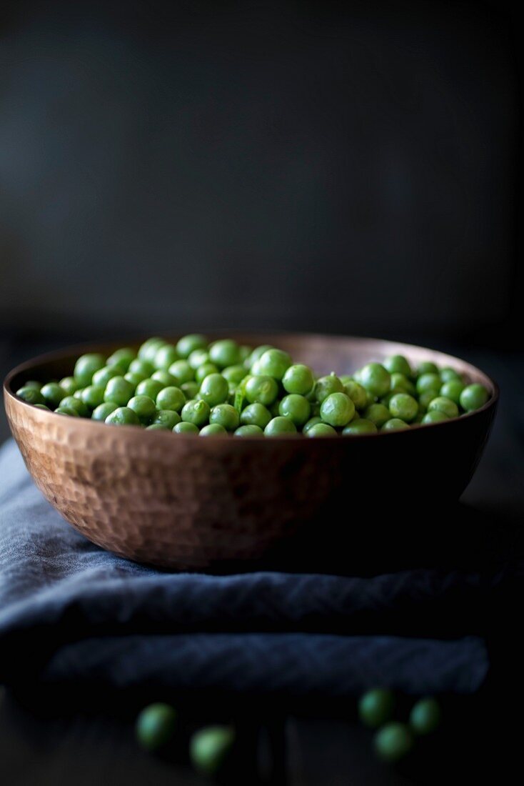 Peas in a bowl on a dark background