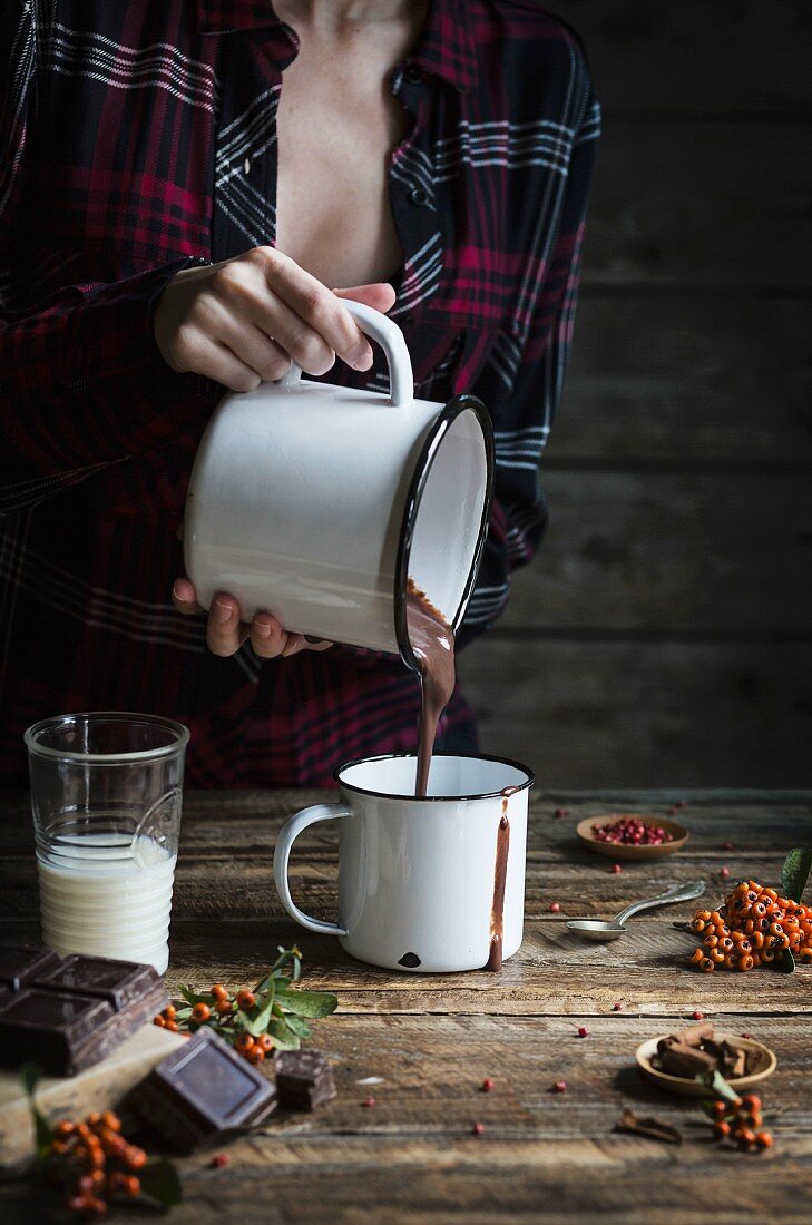 Woman pouring hot chocolate in a mug