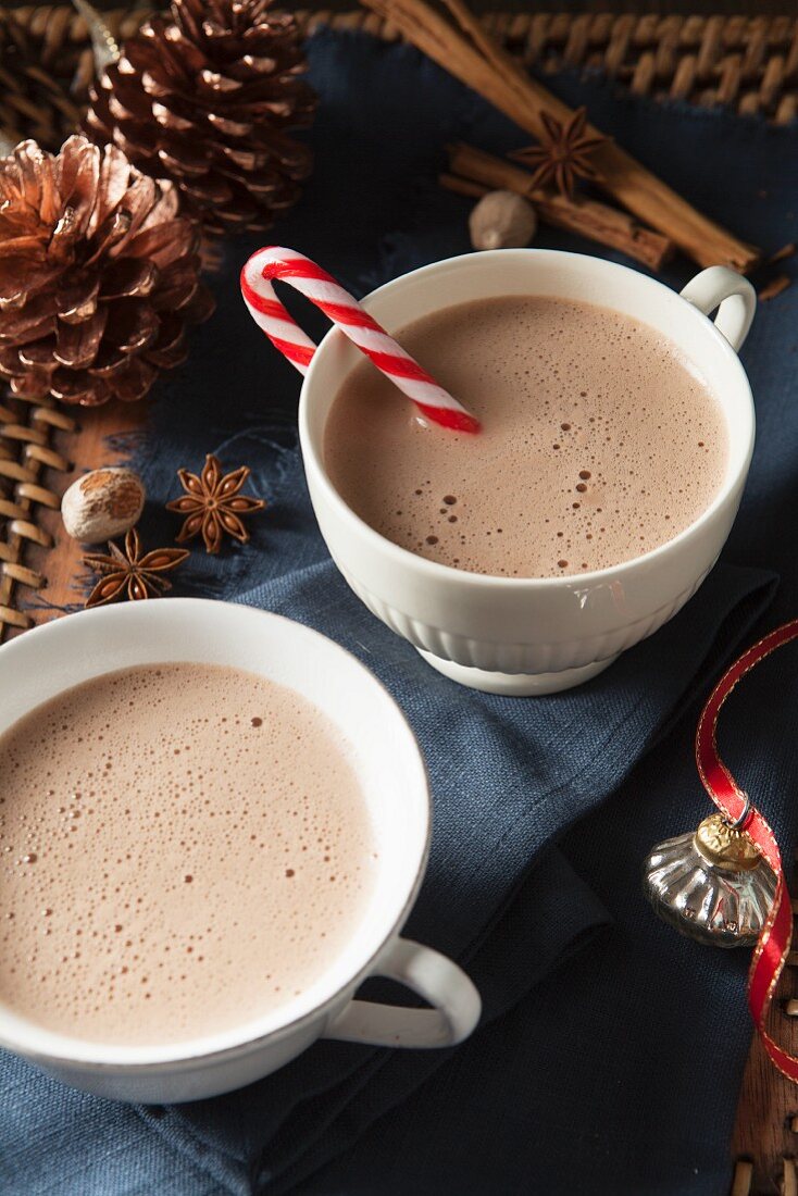 Zwei Tassen Kakao (eine mit Zuckerstange) zu Weihnachten