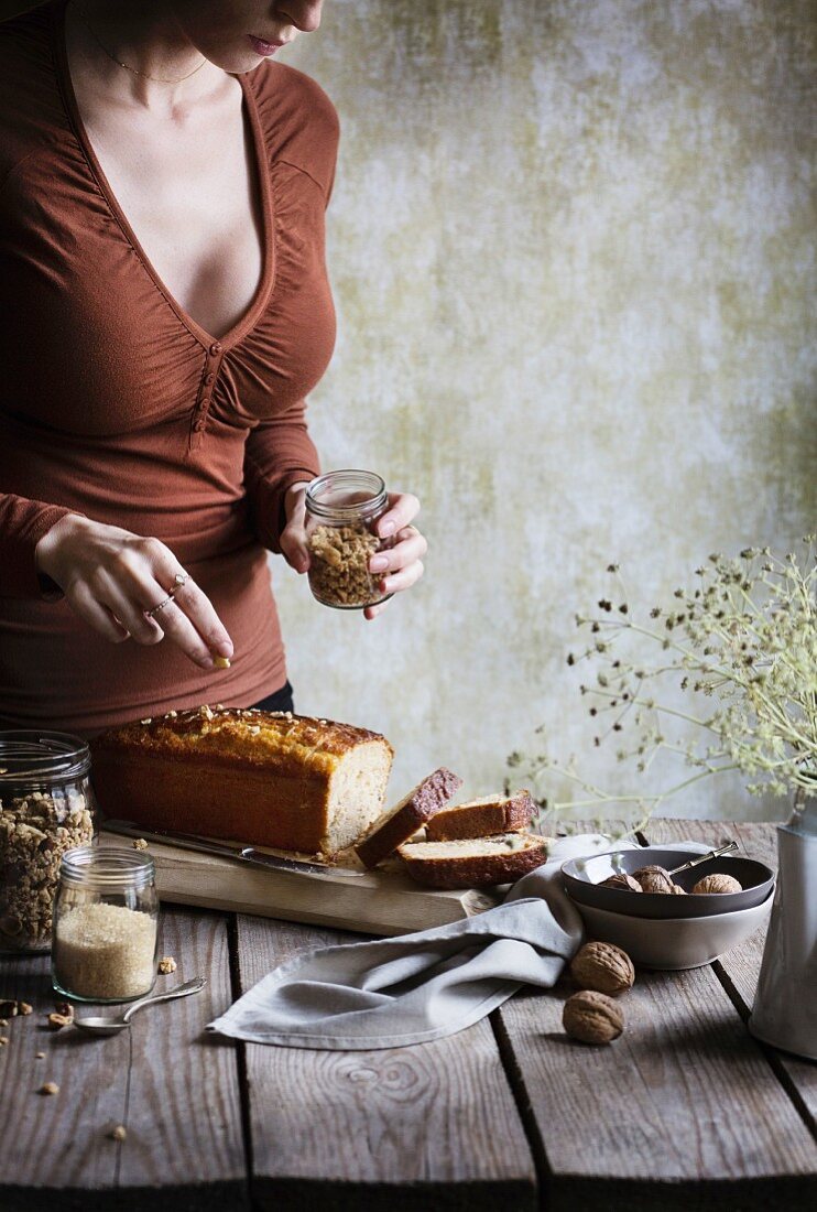 Frau streut Müsli auf einen Kuchen