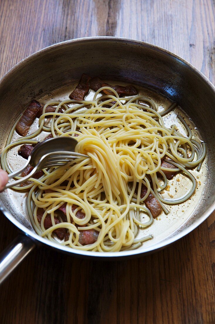 Spaghetti mit Rindfleisch in Pfanne mit Besteck