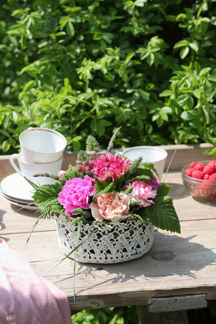 Arrangement of carnations in lacy basket