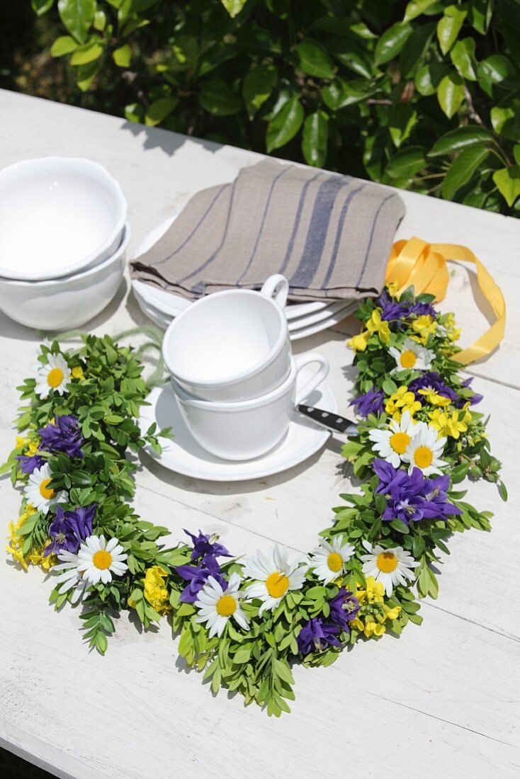 Garland of ox-eye daisies, rapeseed and blue aquilegia