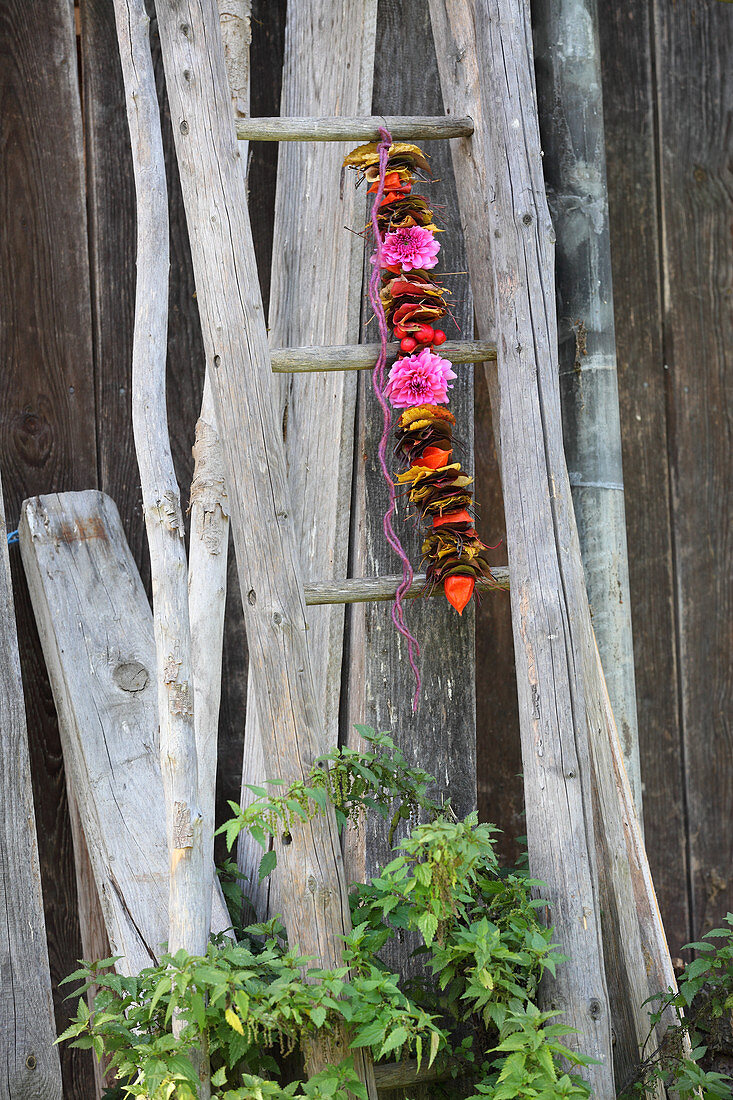 Girlande aus aufgefädeltem Herbstlaub und Blumen