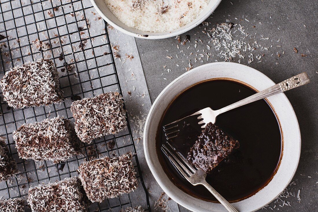 Making Lamingtons - dipping in chocolate icing