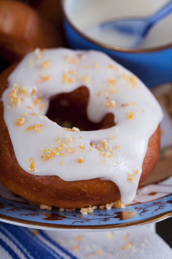 A doughnut with lemon icing and candied orange pieces