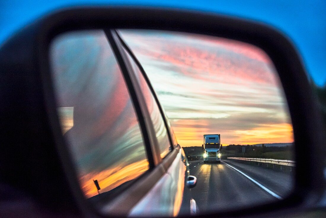 The view of a truck through a wing mirror on the Trans-Canada Highway in Canada