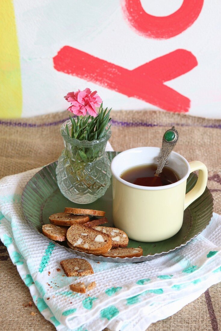 Cantuccini zum Kaffee in Emailletasse auf Metallteller