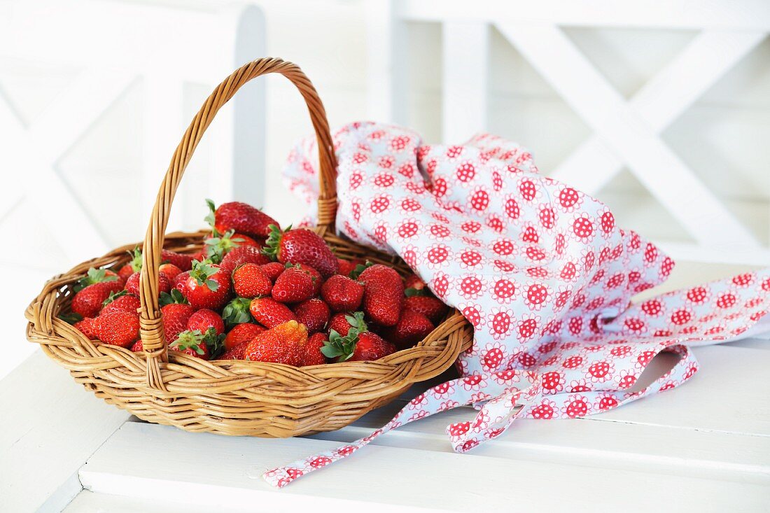 Frische Erdbeeren im Korb auf Holzbank