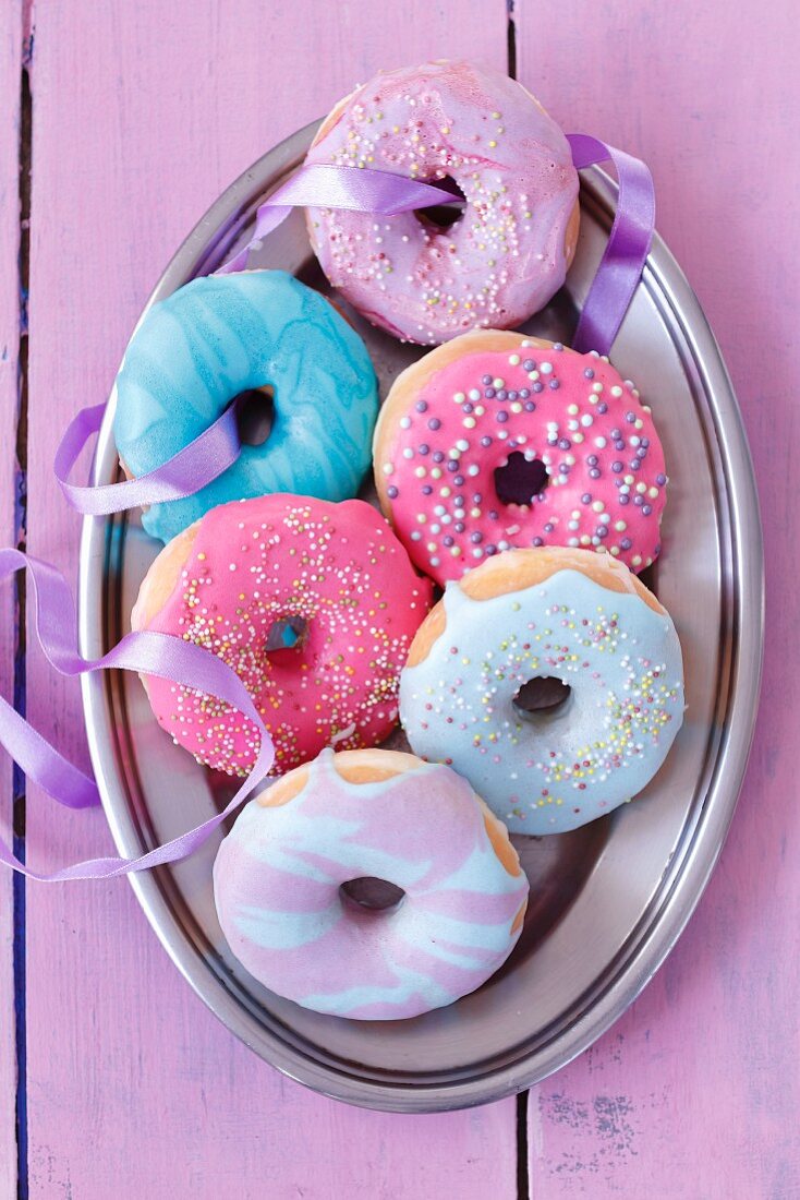 Doughnuts with brightly coloured icing and sugar sprinkles