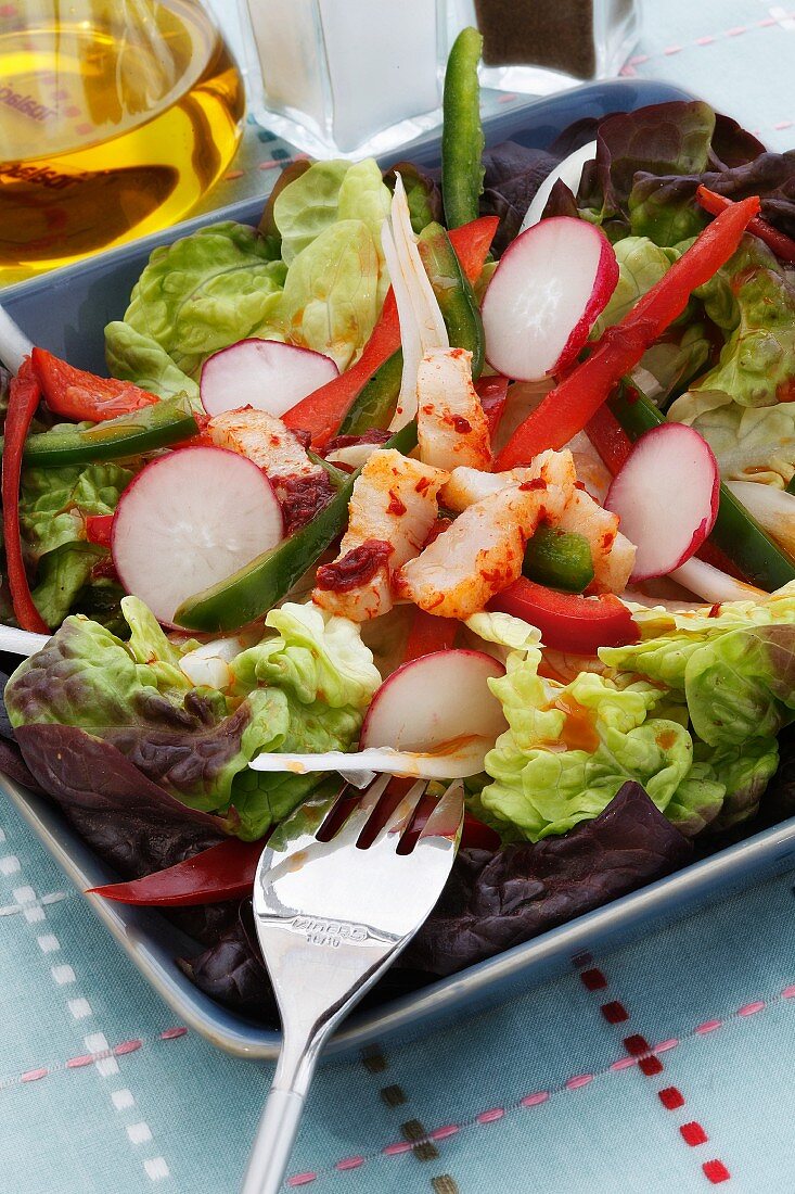 A green salad with radishes and cod