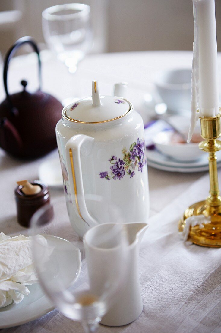 Wine glasses, a coffee pot, food and a candlestick for after dinner