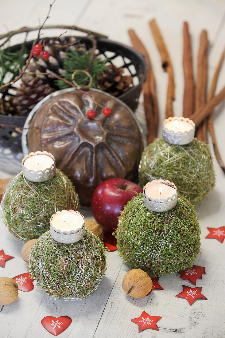 Tealights in crowns on four moss balls tied with silver wire