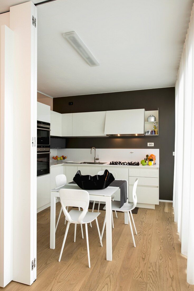 Dining table and wooden floor in black and white kitchen