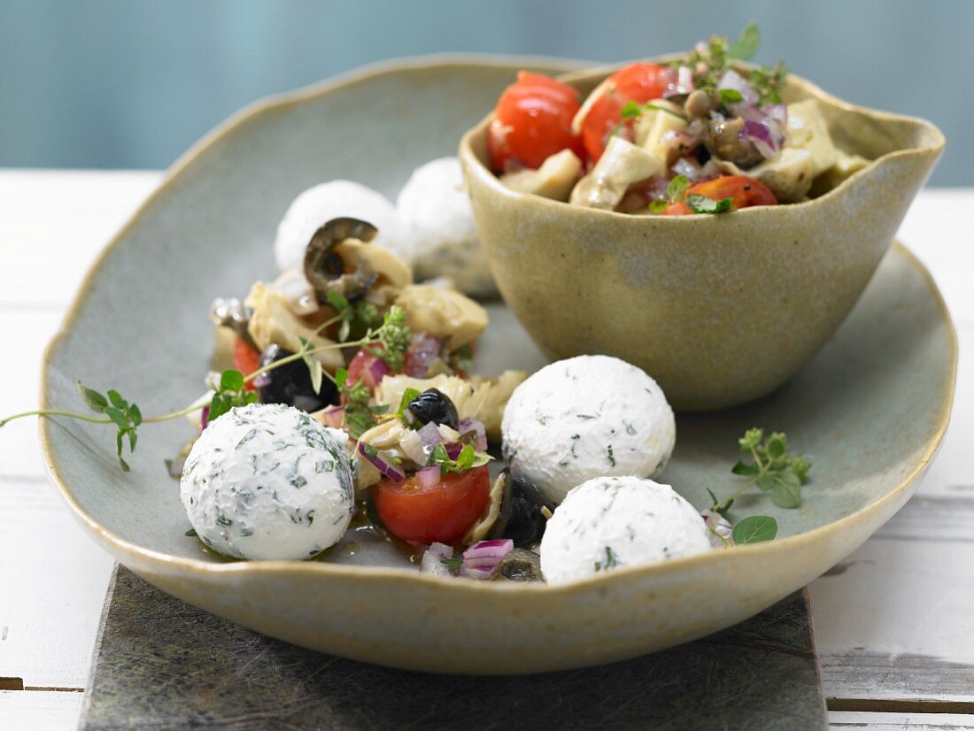Small herb and cream cheese balls with marinated vegetables and oregano
