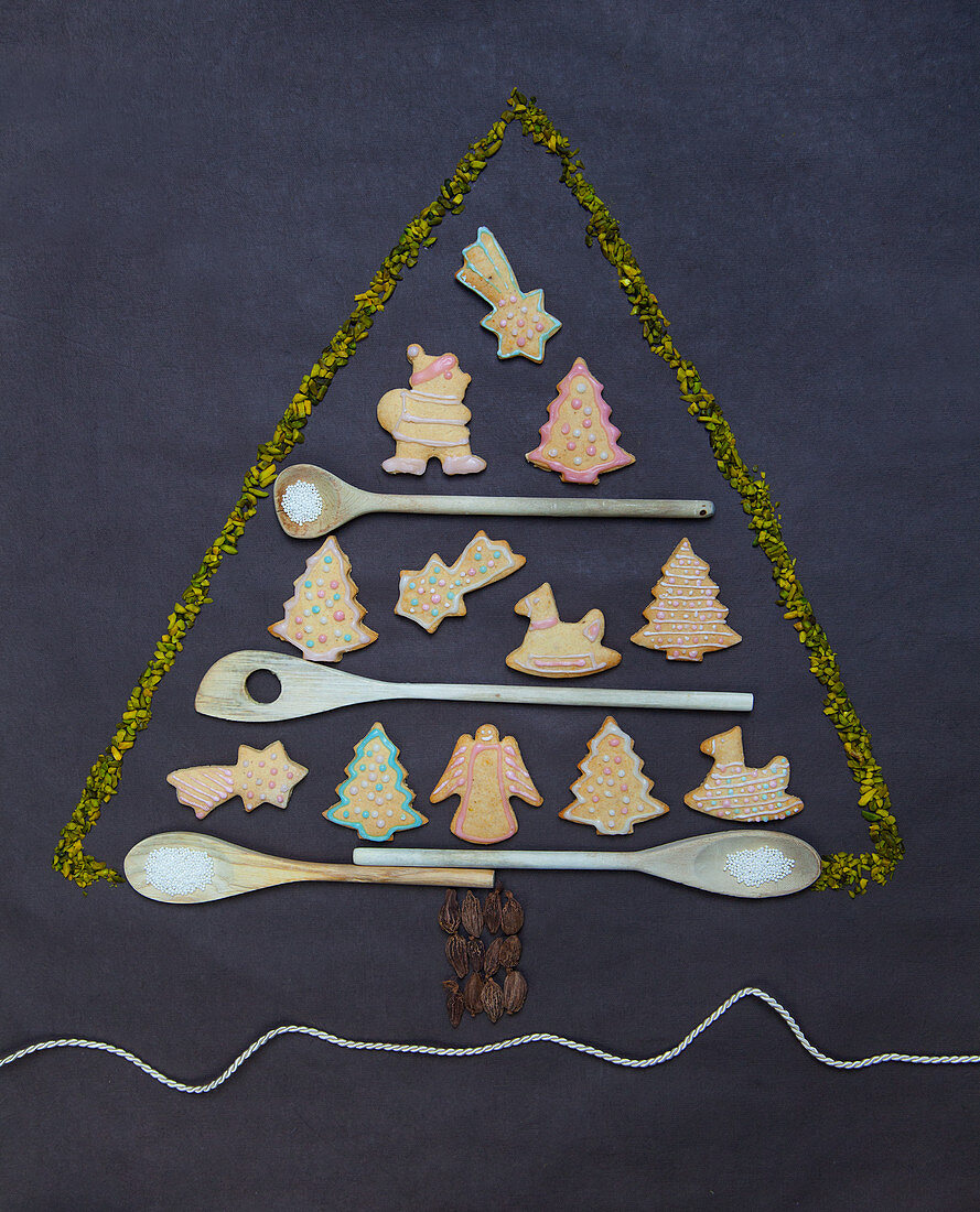 Gingerbread biscuits and wooden spoons in the shape of a Christmas tree