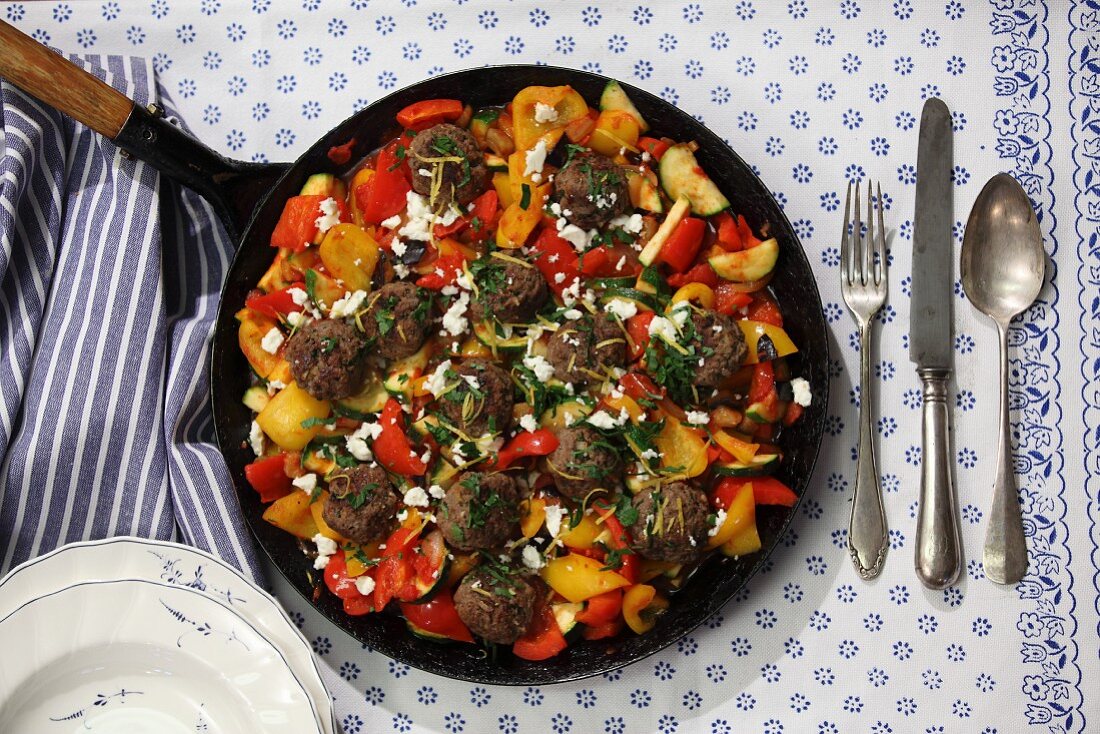 Vegetables in a pan with lemon meatballs