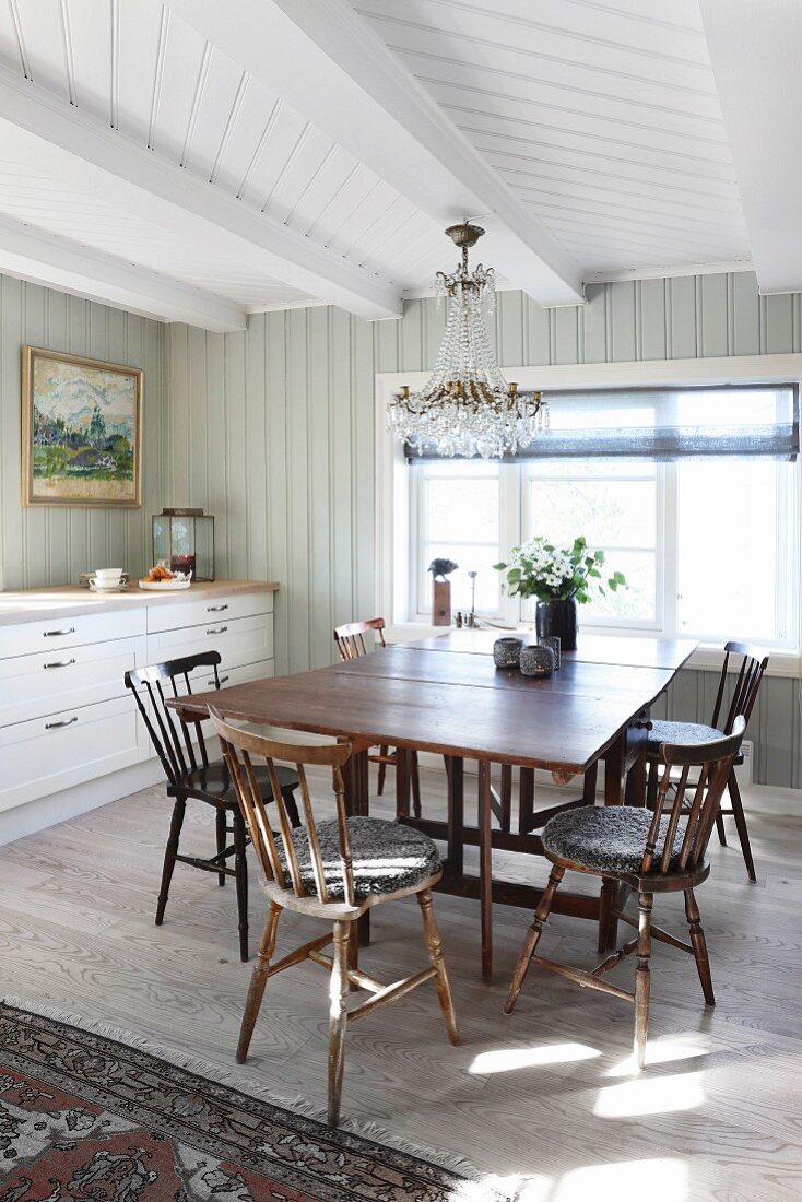 Drop-leaf table in bright dining area in front of kitchen counter