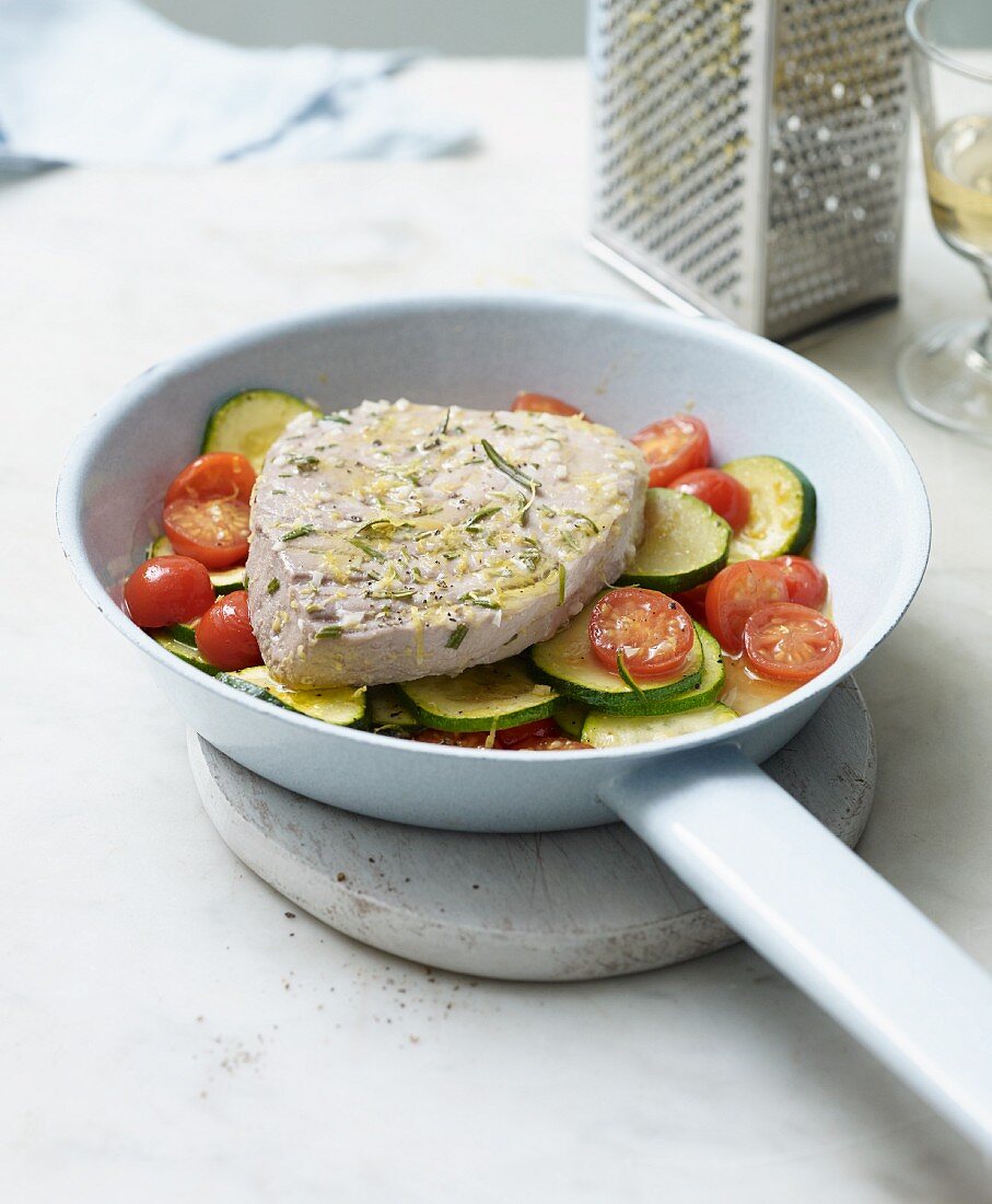 Marinated tuna steak on a bed of tomato and courgette