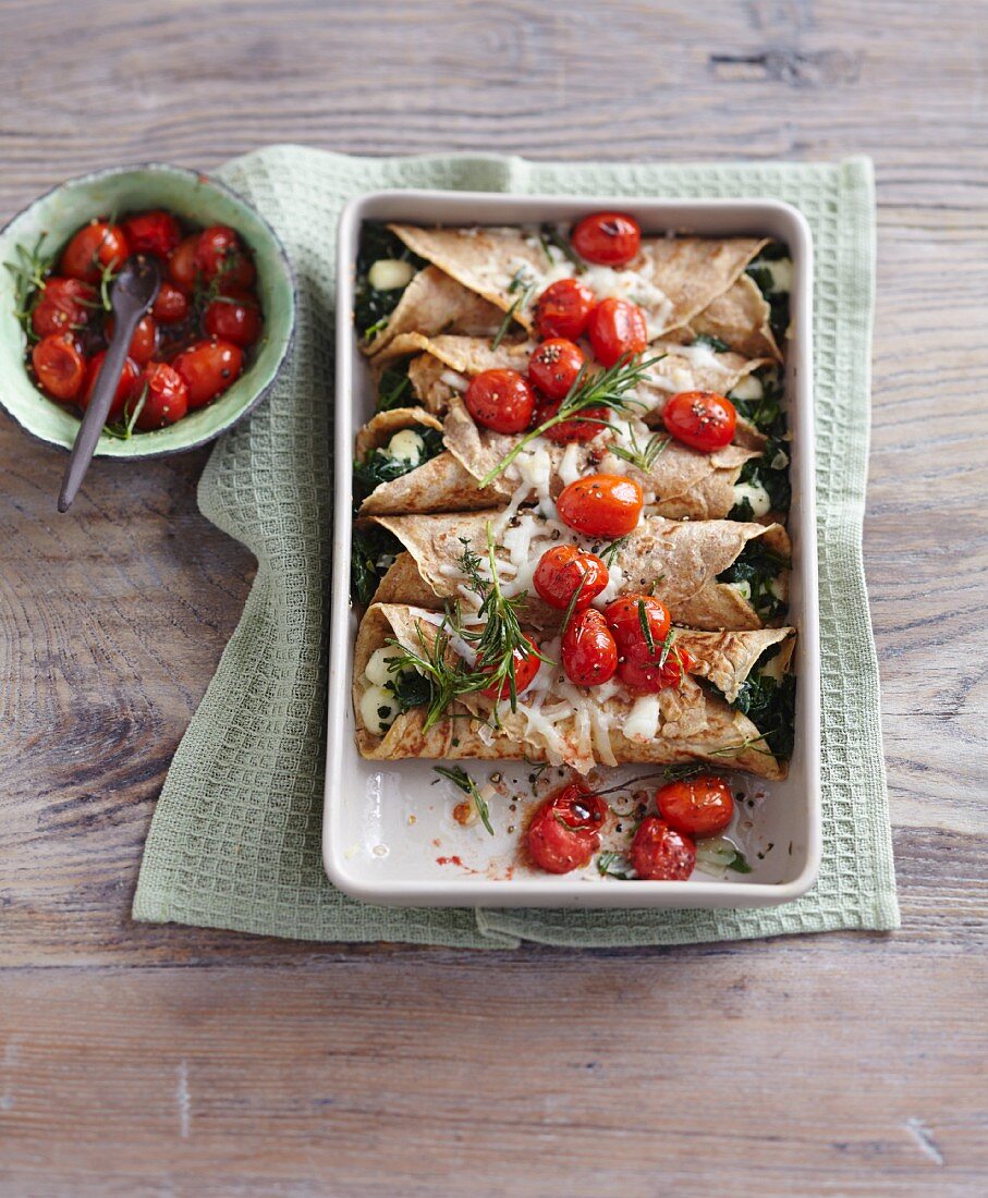 Crespelle au gratin filled with spinach and cherry tomatoes