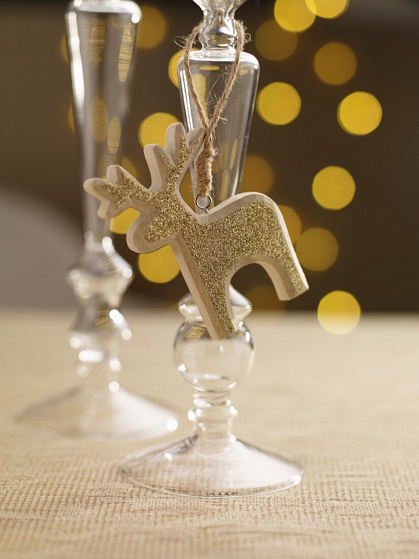 A candlestick holder with a golden reindeer figure on a festively set table