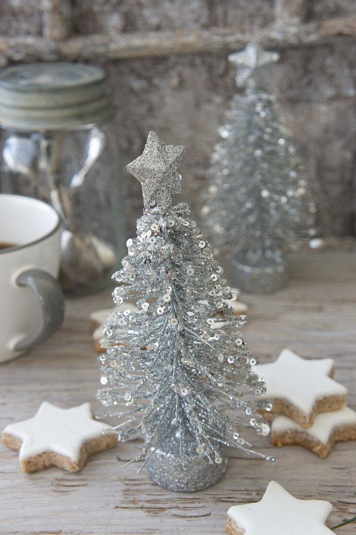 Arrangement of cinnamon stars and silver Christmas-tree ornaments