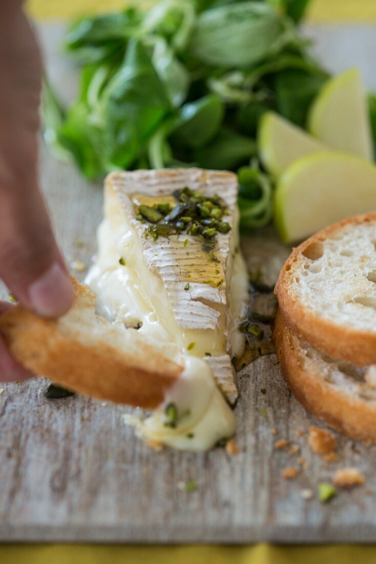 Brie mit Honig, Pistazien, Baguette, Feldsalat und Apfel