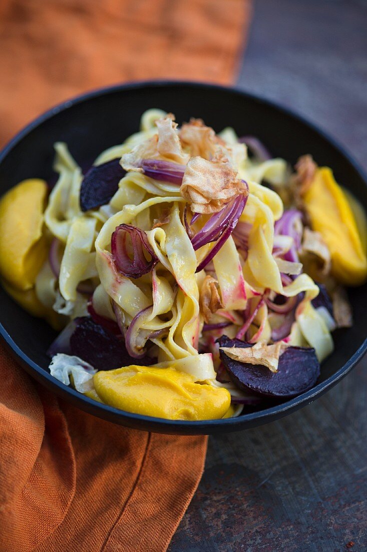Ribbon noodles with pumpkin puree, red beetroot and red onions