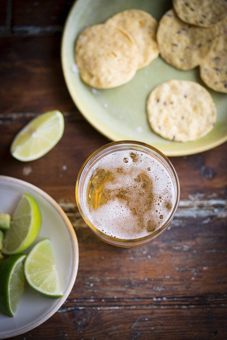 A glass of lager, limes and corn chips