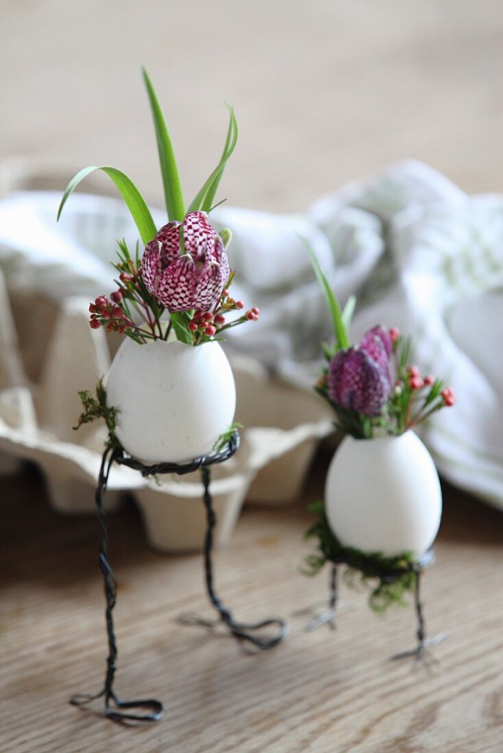Flowers arranged in blown eggs on wire legs