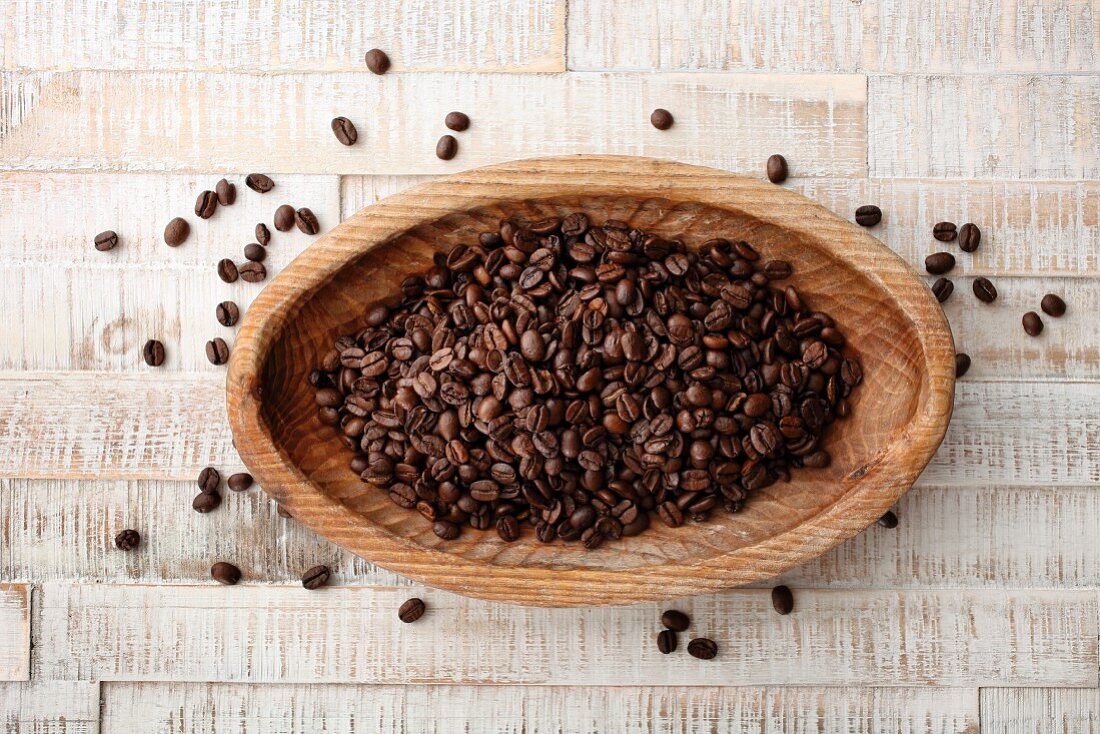 Coffee beans in a wooden bowl (seen from above)