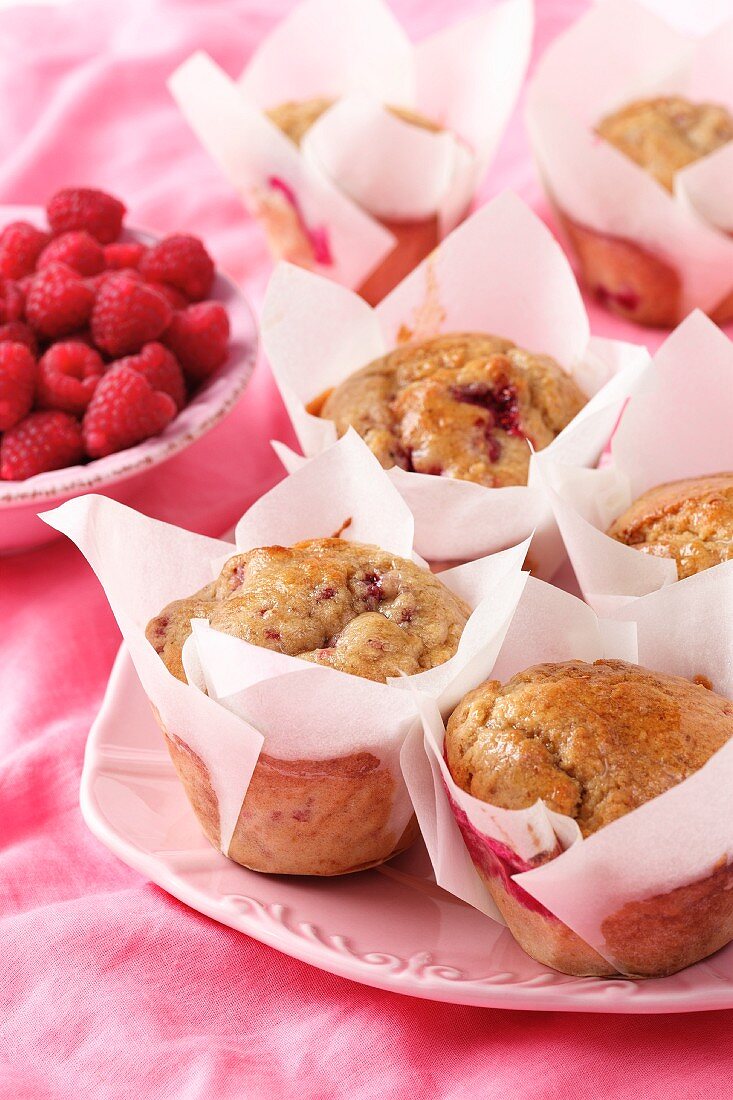 Raspberry cranachan muffins in while cupcake cases on a pink plate