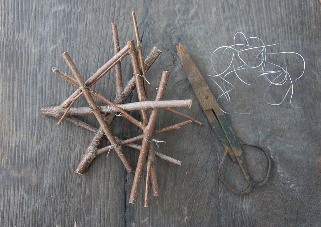 Steckhilfe aus Ästchen mit Draht fixiert, daneben Vintage Schere