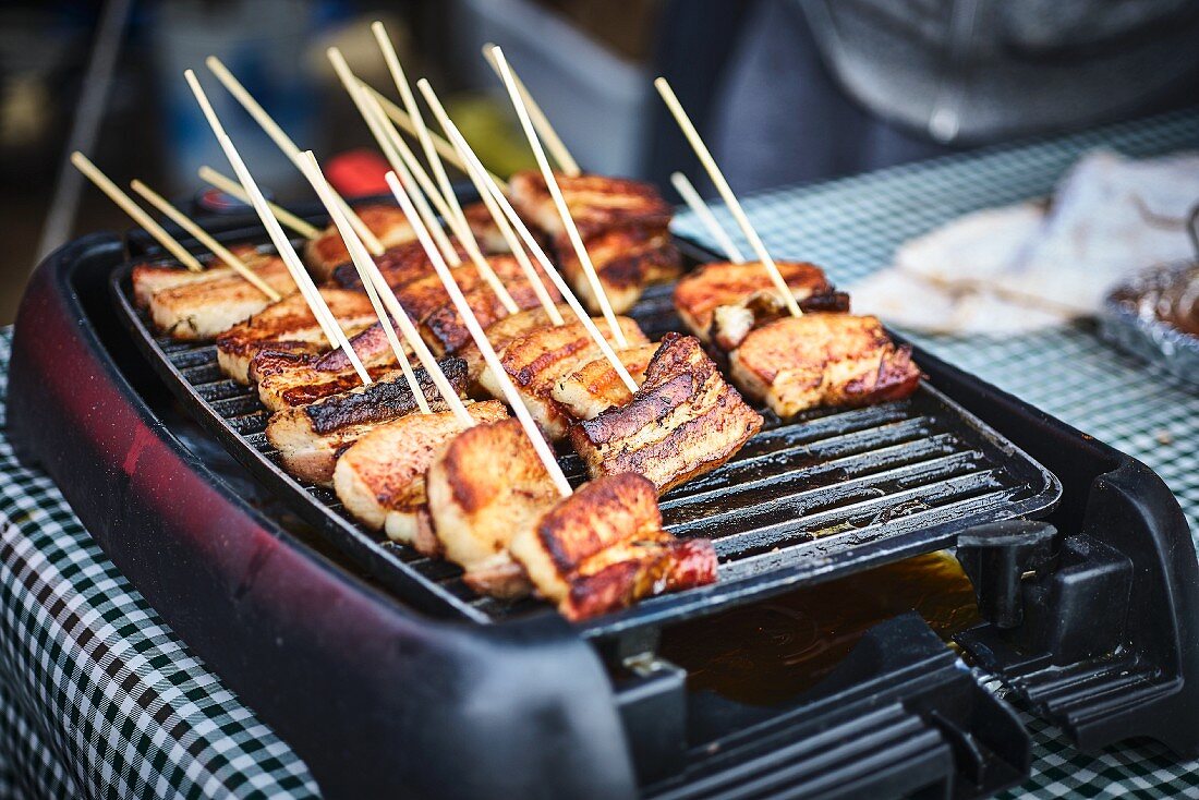 Pork belly sticks in a street kitchen