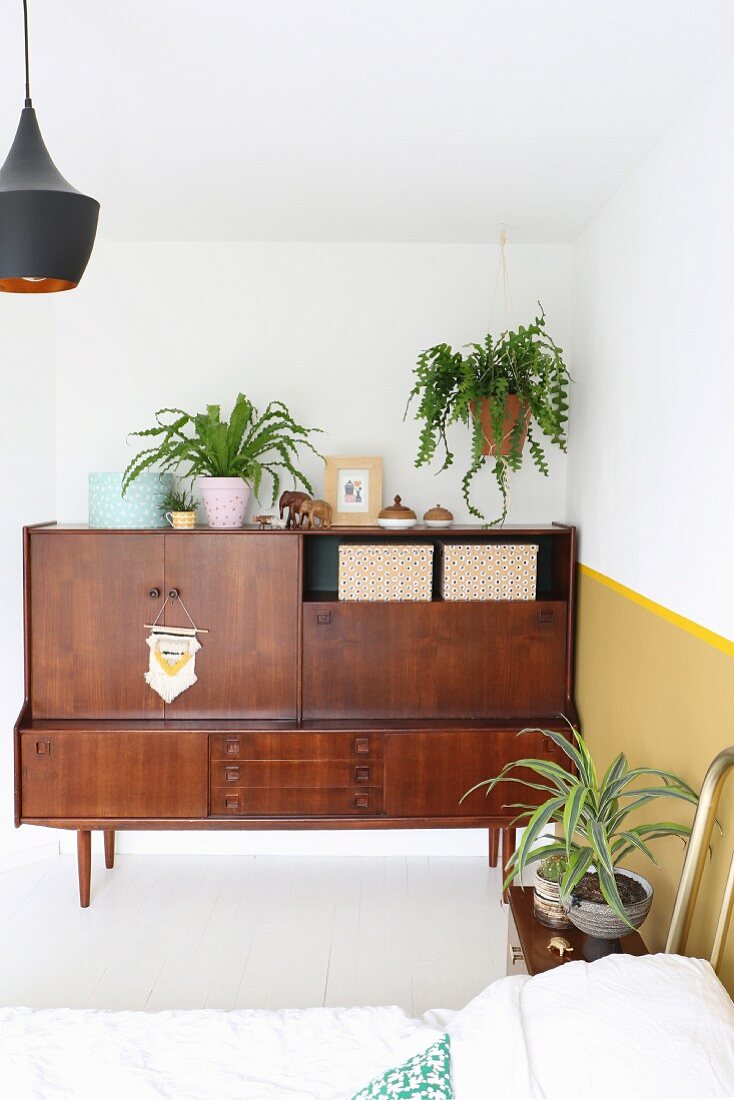 Zimmerpflanzen und Retro Sideboard in Zimmerecke