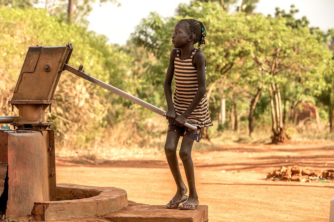 Young girl pumping water
