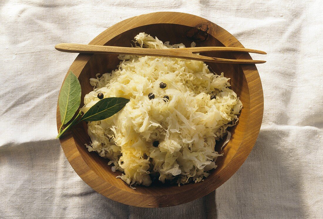 Sauerkraut with juniper berries in wooden bowl