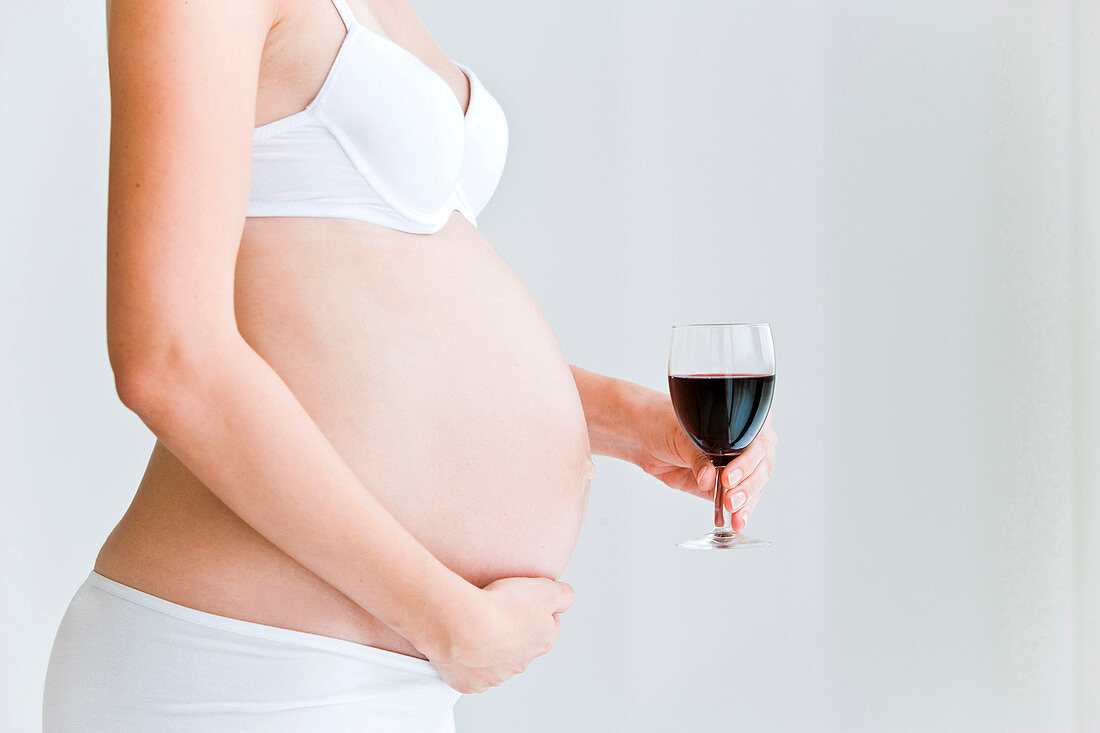 Pregnant woman with a glass of wine