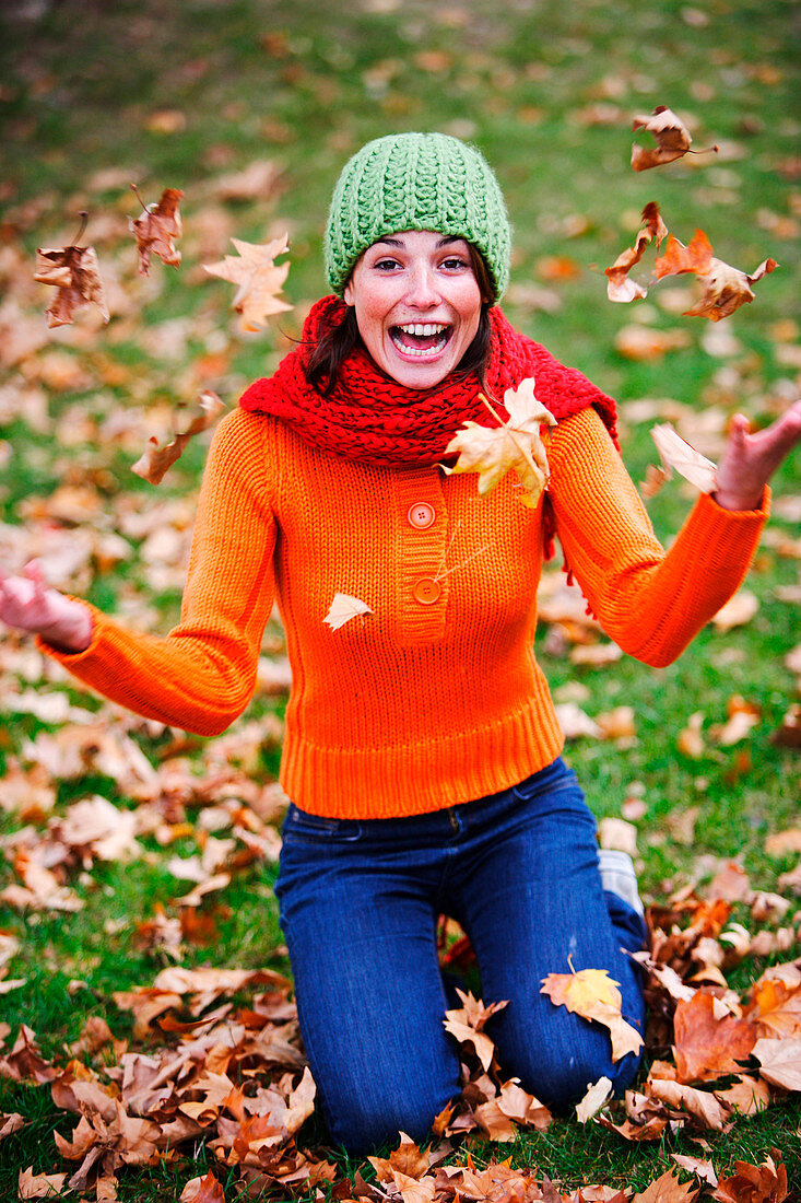 Woman with dead leaves in autumn