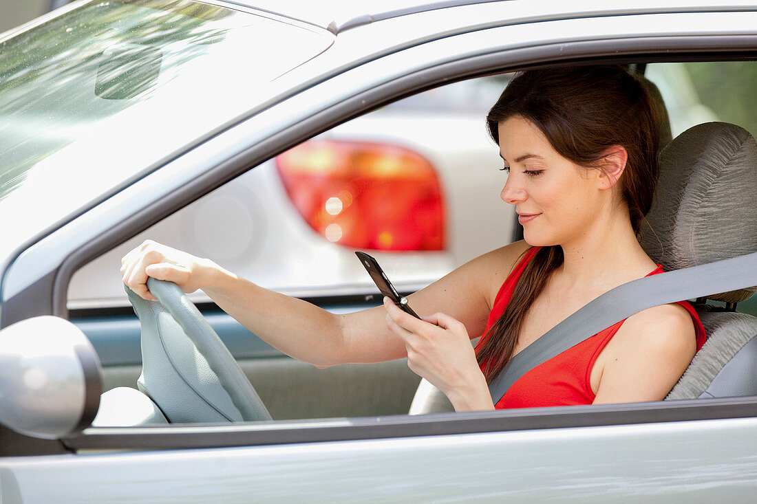 Woman using cell phone while driving
