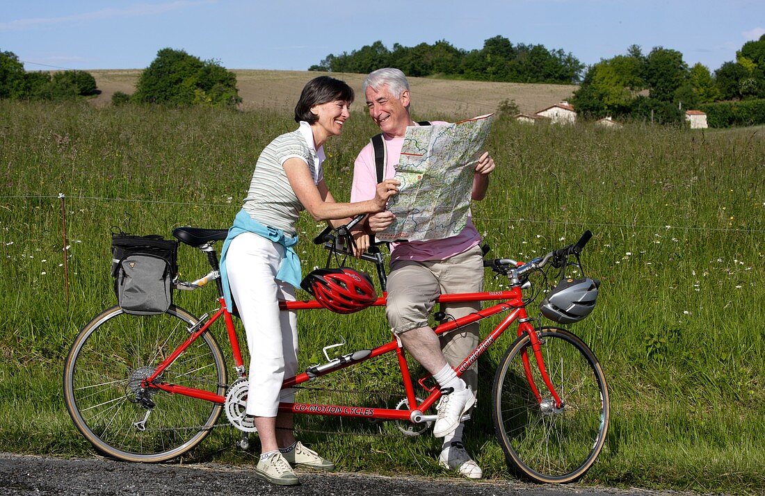 Senior couple riding tandem bicycle