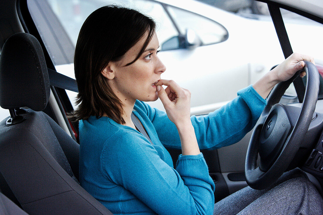 Stressed driver biting her nails