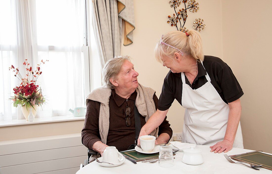 Care home resident being served tea