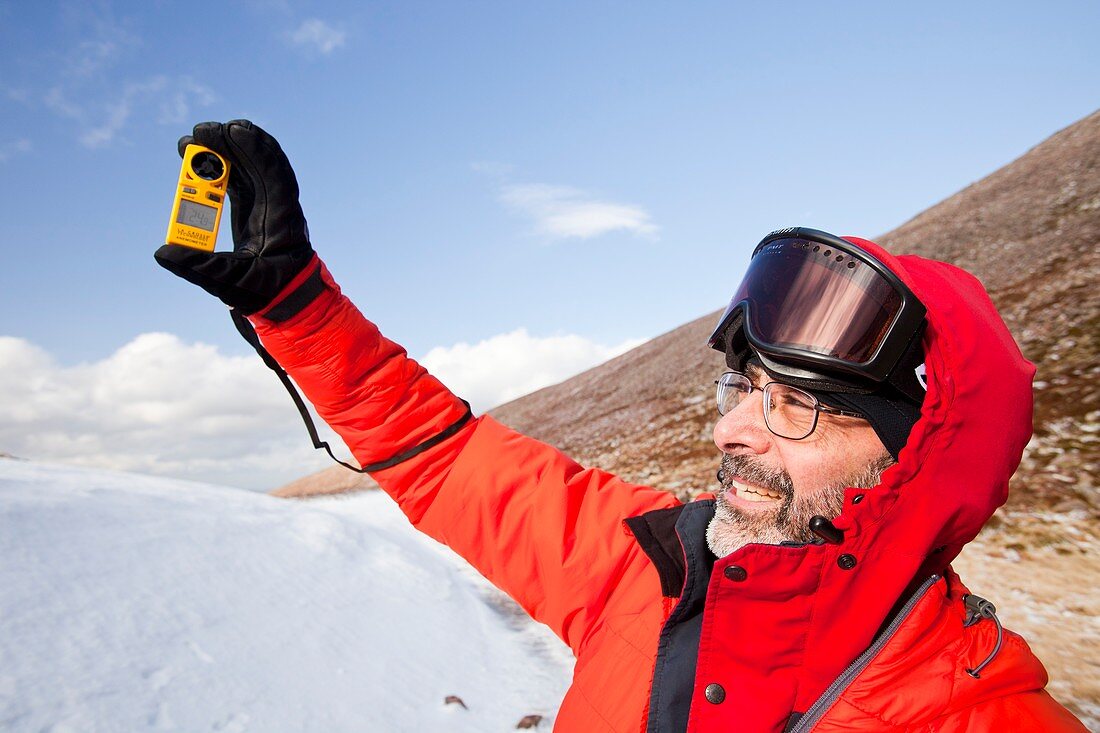 Mountaineer using an anemometer