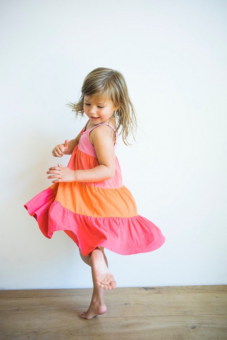 Kleines Mädchen tanzt in Volantkleid