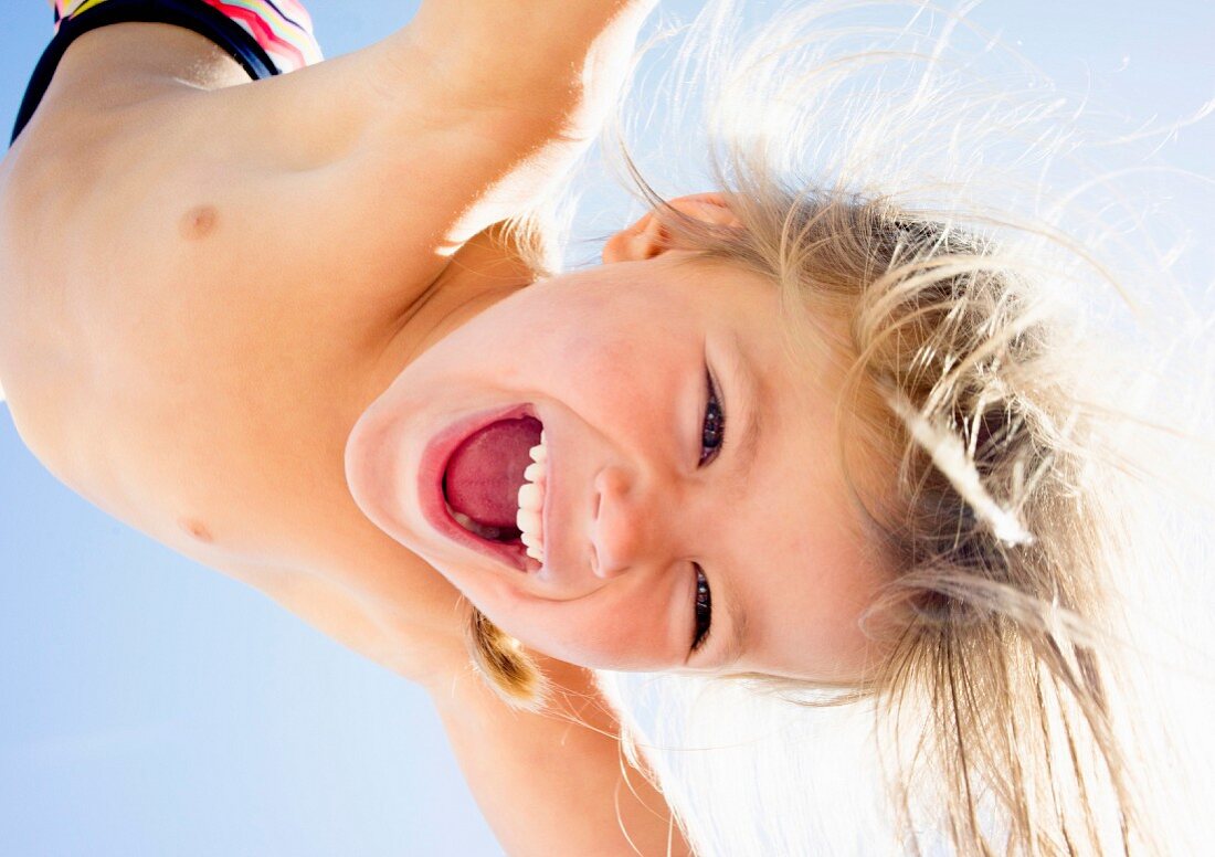A laughing little girl photographed from below